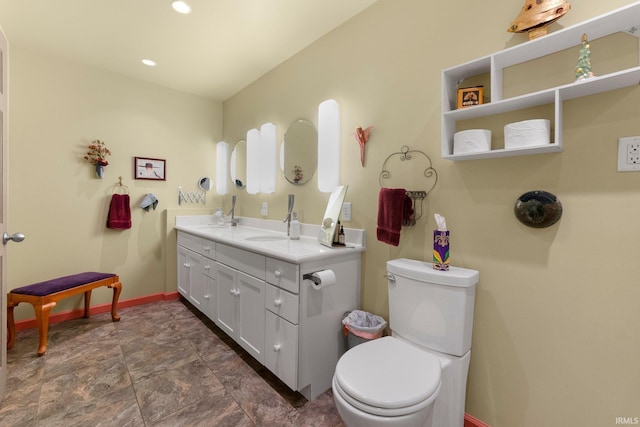 2905 E Mowrey Rd, Columbia City, IN 46725 - bathroom with double vanity, toilet, stone finish floors, baseboards, and recessed lighting