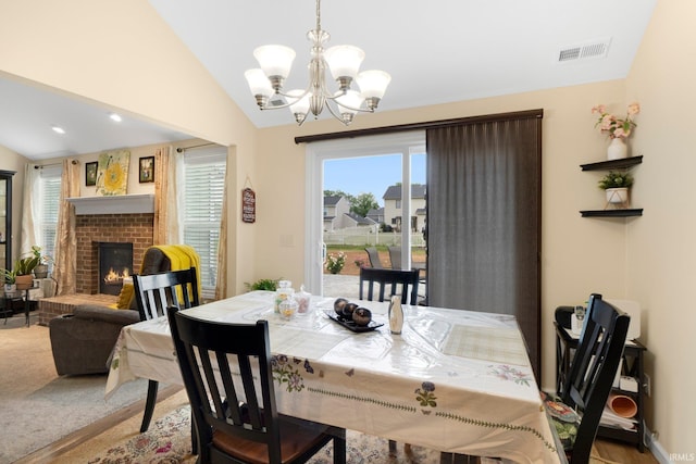 2082 Hemlock Ln, Warsaw, IN 46580 - dining space with a chandelier, vaulted ceiling, and a brick fireplace