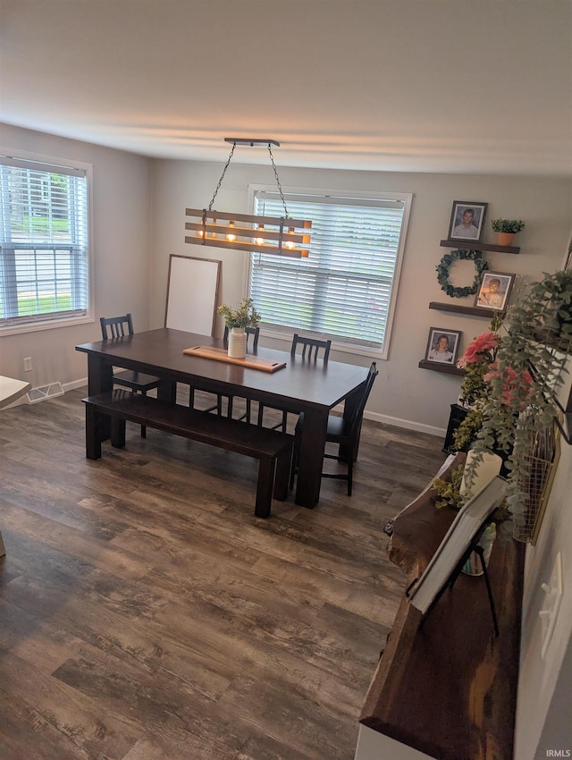 664 Columbia St, Berne, IN 46711 - dining space featuring baseboards, dark wood-style floors, and a chandelier