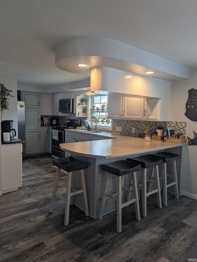 664 Columbia St, Berne, IN 46711 - kitchen featuring stainless steel appliances, dark wood-style flooring, a peninsula, and tasteful backsplash