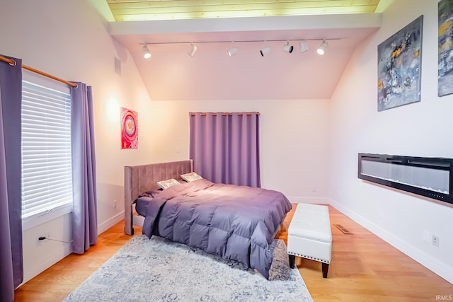 2910 W Devon Rd, Muncie, IN 47304 - bedroom featuring vaulted ceiling, rail lighting, light wood finished floors, and baseboards