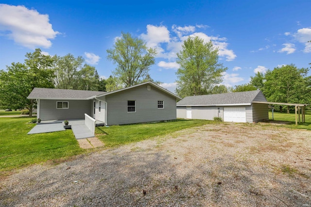 9129 Winchester Rd, Fort Wayne, IN 46819 - back of house featuring a lawn, a detached garage, an outdoor structure, and a shingled roof