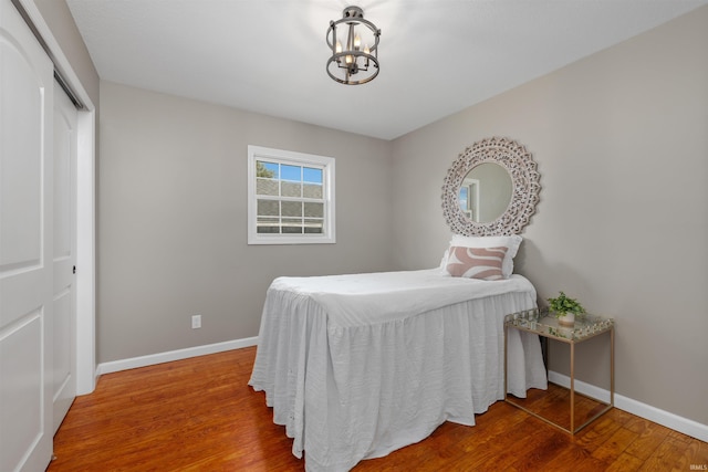 9129 Winchester Rd, Fort Wayne, IN 46819 - bedroom featuring a chandelier, wood finished floors, baseboards, and a closet