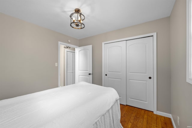 9129 Winchester Rd, Fort Wayne, IN 46819 - bedroom featuring a closet, wood finished floors, a chandelier, and baseboards