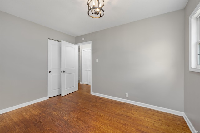 9129 Winchester Rd, Fort Wayne, IN 46819 - unfurnished bedroom featuring a chandelier, baseboards, and wood finished floors