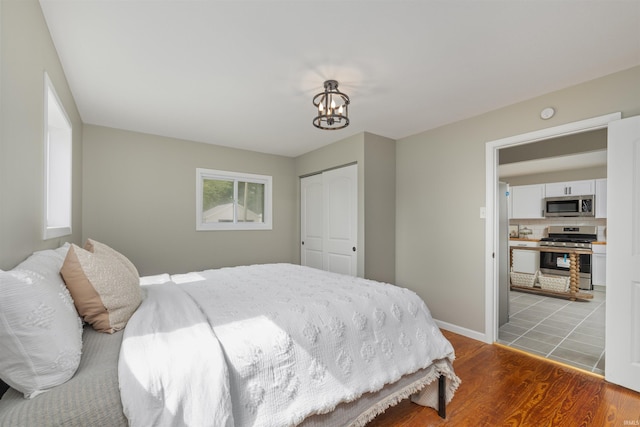 9129 Winchester Rd, Fort Wayne, IN 46819 - bedroom with a closet, light wood-style floors, a chandelier, and baseboards