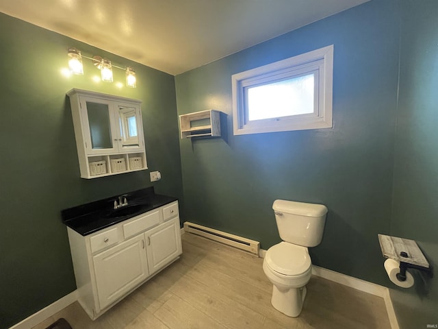 304 E 26th St, Muncie, IN 47302 - bathroom featuring a baseboard radiator, toilet, vanity, baseboards, and wood finished floors