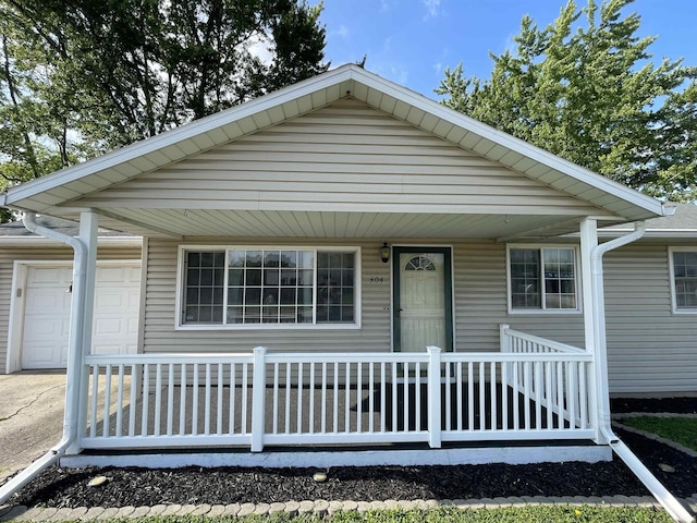 304 E 26th St, Muncie, IN 47302 - view of front of property featuring a porch, a garage, and driveway