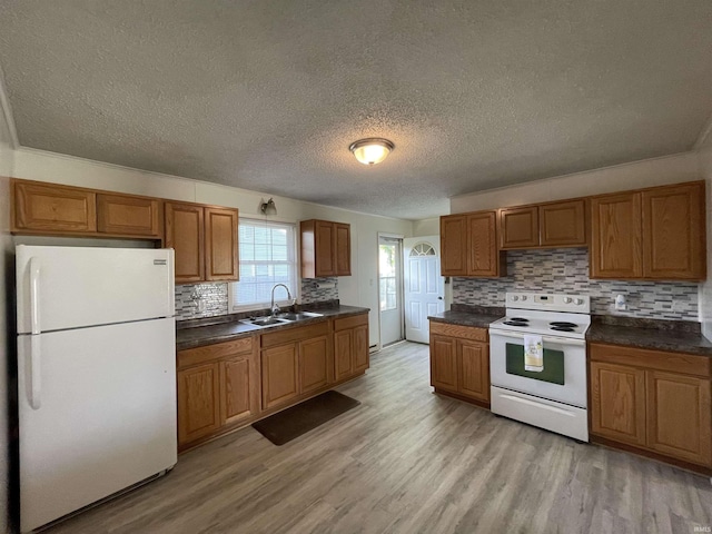 304 E 26th St, Muncie, IN 47302 - kitchen with white appliances, a sink, dark countertops, brown cabinetry, and a textured ceiling