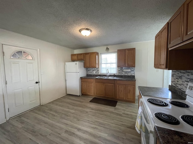 304 E 26th St, Muncie, IN 47302 - kitchen featuring white appliances, dark countertops, a sink, tasteful backsplash, and a textured ceiling