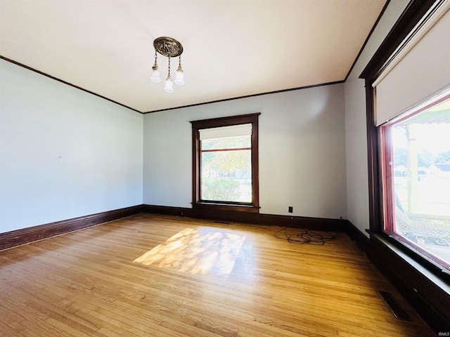 201 N Lafayette St, North Liberty, IN 46554 - empty room with a chandelier, healthy amount of natural light, ornamental molding, light wood-style floors, and baseboards