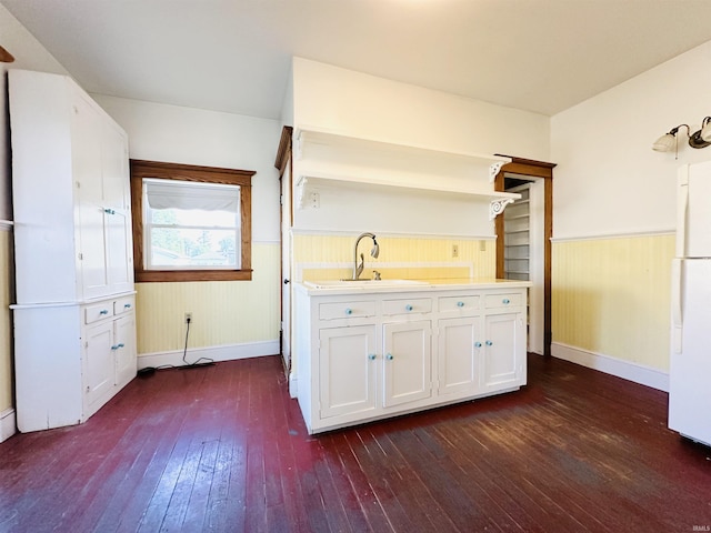 201 N Lafayette St, North Liberty, IN 46554 - kitchen featuring freestanding refrigerator, dark wood-style floors, a wainscoted wall, a sink, and white cabinets