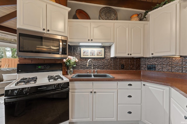 61560 Druid Ln, South Bend, IN 46614 - kitchen with gas stove, stainless steel microwave, a sink, white cabinetry, and tile patterned flooring