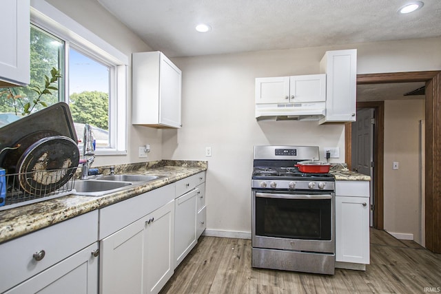 3311 Ardmore Trl, South Bend, IN 46628 - kitchen with stainless steel range with gas stovetop, under cabinet range hood, light wood finished floors, white cabinets, and recessed lighting