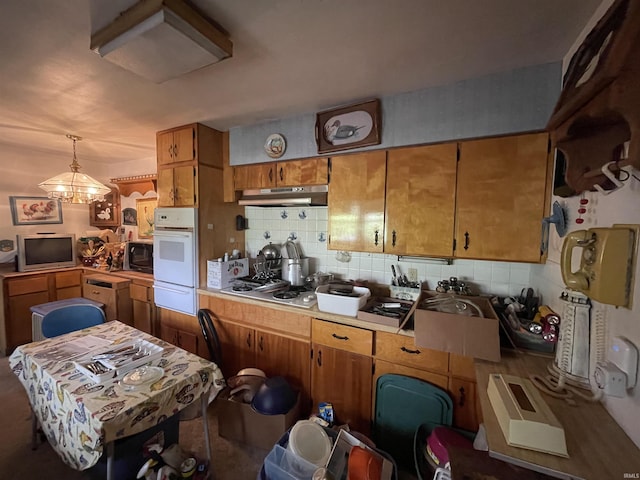 520 S Butterfield Rd, Muncie, IN 47302 - kitchen with under cabinet range hood, oven, a warming drawer, black microwave, and decorative backsplash