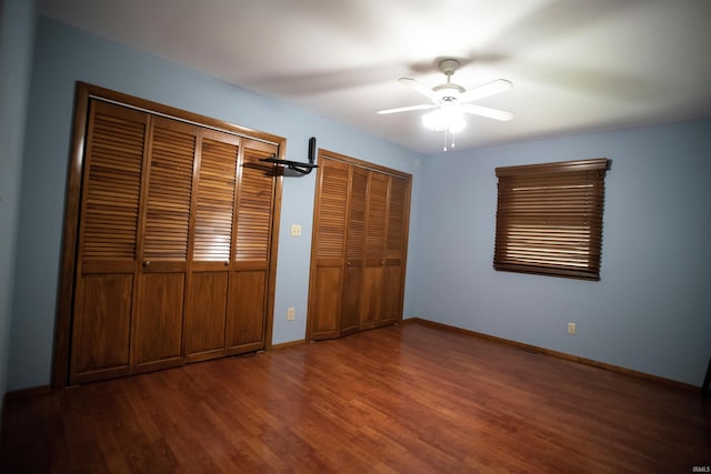 5101 Weir Dr, Muncie, IN 47304 - unfurnished bedroom with wood finished floors, baseboards, multiple closets, and ceiling fan