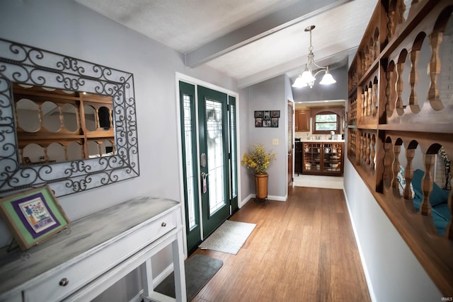 5101 Weir Dr, Muncie, IN 47304 - entryway featuring beamed ceiling, wood finished floors, a chandelier, and baseboards