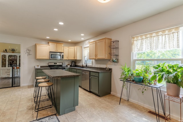 863 S Melchior Dr, Santa Claus, IN 47579 - kitchen with stainless steel appliances, light brown cabinetry, dark countertops, decorative backsplash, and recessed lighting