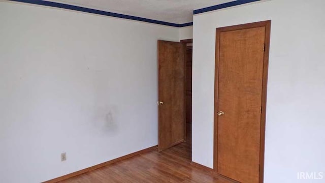 1001 Barnett St, Vincennes, IN 47591 - empty room with wood finished floors, ornamental molding, and baseboards
