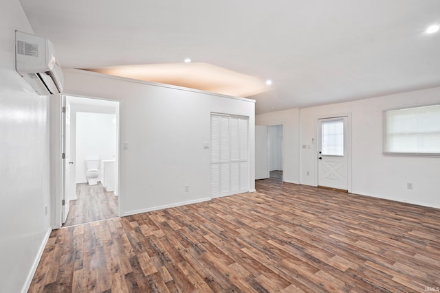415 N Washington St, Warsaw, IN 46580 - unfurnished living room with a wall unit AC, wood finished floors, recessed lighting, and baseboards
