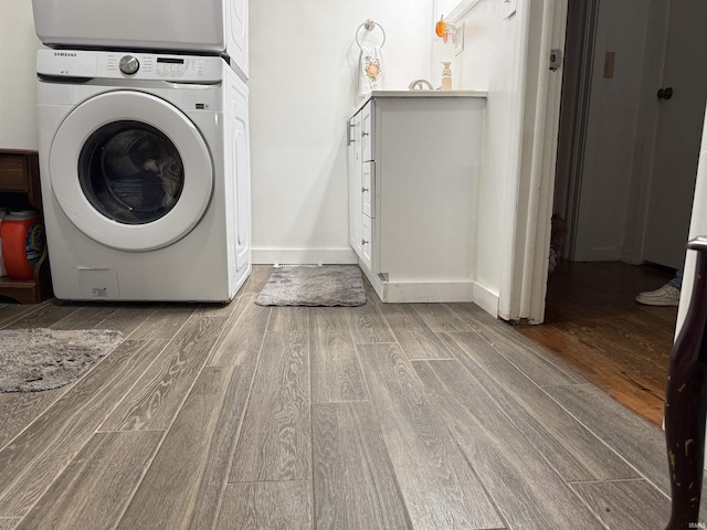 2702 Eastern Ave, Bedford, IN 47421 - laundry area with stacked washing machine and dryer, wood finished floors, and baseboards