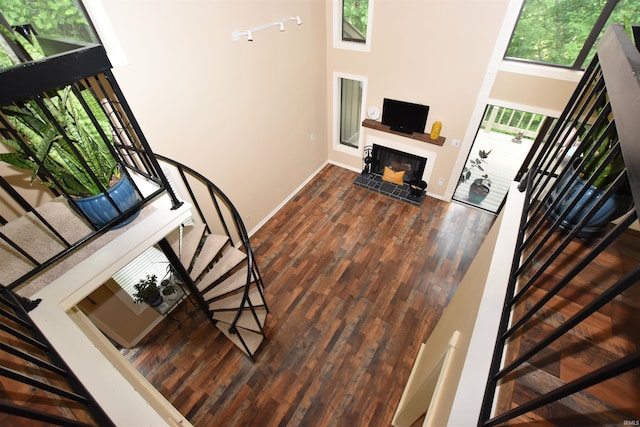 9428 S Lake Ridge Dr, Bloomington, IN 47401 - stairs with a fireplace with raised hearth, baseboards, a towering ceiling, and wood finished floors