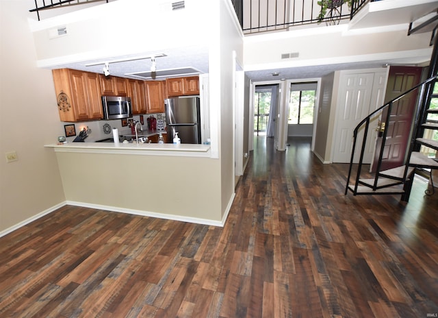 9428 S Lake Ridge Dr, Bloomington, IN 47401 - kitchen with stainless steel appliances, brown cabinetry, baseboards, and dark wood finished floors