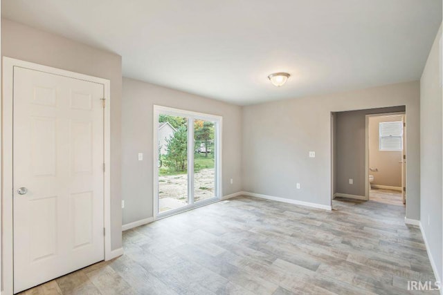 405 Somerfield Dr, Lakeville, IN 46536 - unfurnished bedroom with access to exterior, baseboards, and light wood-style flooring