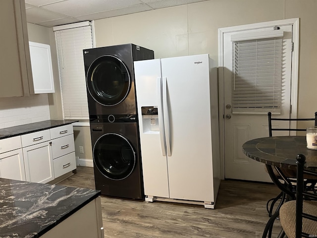 514 N Elliott St, Evansville, IN 47711 - kitchen with white fridge with ice dispenser, estacked washer and dryer, dark wood finished floors, white cabinets, and a drop ceiling