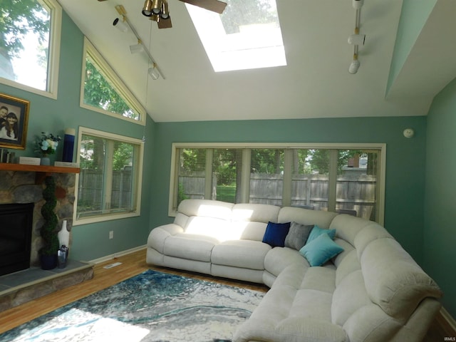 53341 Crestview Dr, South Bend, IN 46635 - living area featuring track lighting, wood finished floors, ceiling fan, a stone fireplace, and a skylight
