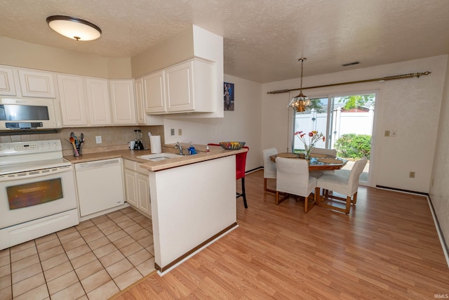 1009 Berkley Cir, Mishawaka, IN 46544 - kitchen featuring white appliances, white cabinetry, light wood-style flooring, light countertops, and a textured ceiling
