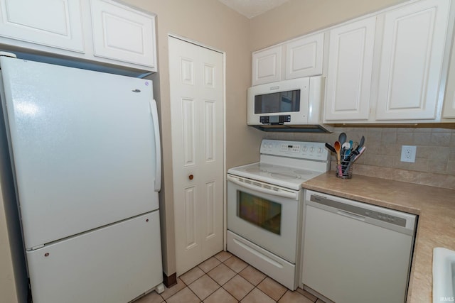 1009 Berkley Cir, Mishawaka, IN 46544 - kitchen with white appliances, white cabinetry, light countertops, tasteful backsplash, and light tile patterned floors