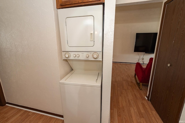 1009 Berkley Cir, Mishawaka, IN 46544 - laundry room featuring stacked washer / dryer, wood finished floors, a textured wall, and baseboards