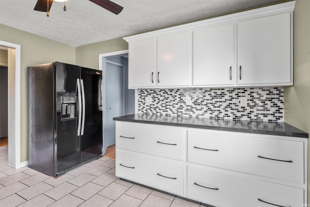 614 E S B St, Gas City, IN 46933 - kitchen with black refrigerator with ice dispenser, dark countertops, white cabinetry, backsplash, and a textured ceiling
