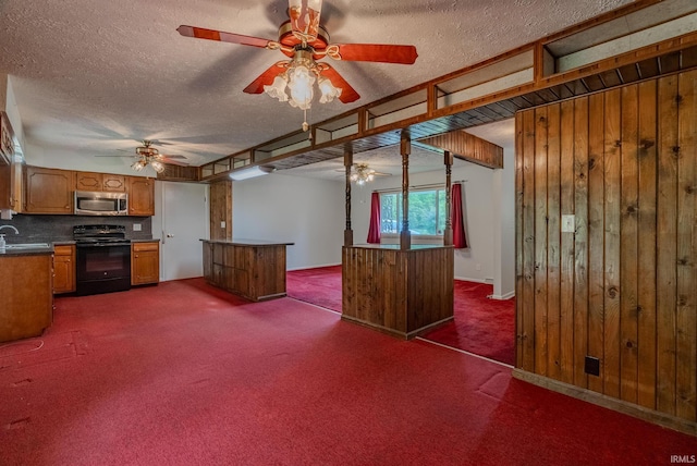 1113 E 500 S, Wabash, IN 46992 - kitchen with black range with electric cooktop, stainless steel microwave, a ceiling fan, a sink, and a textured ceiling