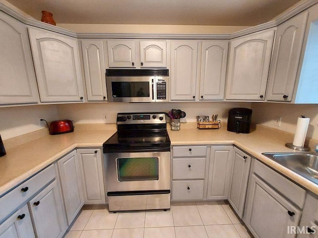 1749 W 1st St, Jasper, IN 47546 - kitchen with stainless steel appliances, light tile patterned flooring, light countertops, and a sink