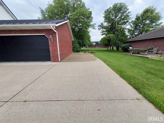 1749 W 1st St, Jasper, IN 47546 - view of side of property with brick siding, a lawn, driveway, and a garage