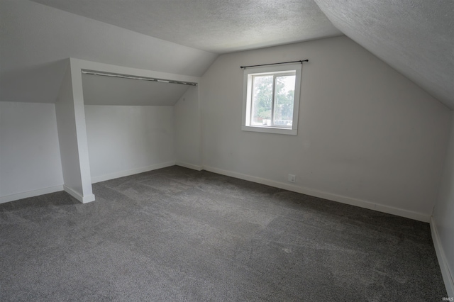 208 N Heaton St, Knox, IN 46534 - bonus room featuring vaulted ceiling, dark colored carpet, a textured ceiling, and baseboards
