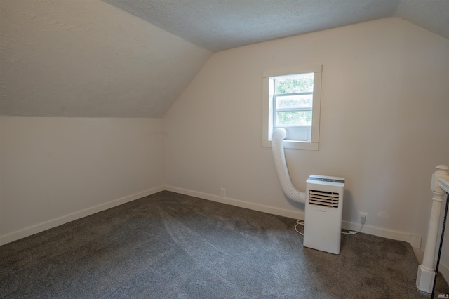 208 N Heaton St, Knox, IN 46534 - additional living space featuring lofted ceiling, dark carpet, baseboards, and a textured ceiling