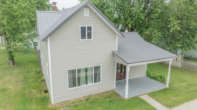 208 N Heaton St, Knox, IN 46534 - rear view of property featuring a patio, metal roof, a yard, and a chimney