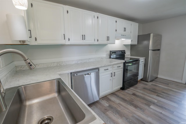 208 N Heaton St, Knox, IN 46534 - kitchen with appliances with stainless steel finishes, under cabinet range hood, a sink, white cabinetry, and light countertops