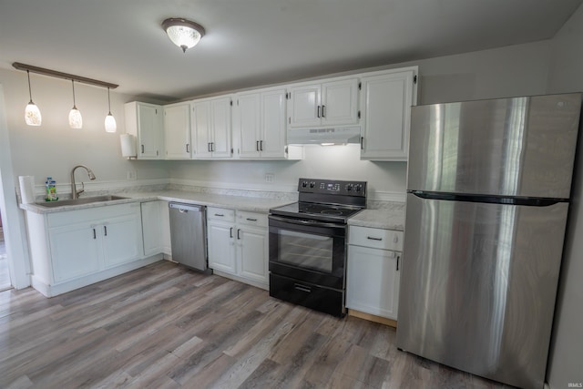 208 N Heaton St, Knox, IN 46534 - kitchen with appliances with stainless steel finishes, under cabinet range hood, a sink, white cabinetry, and light countertops