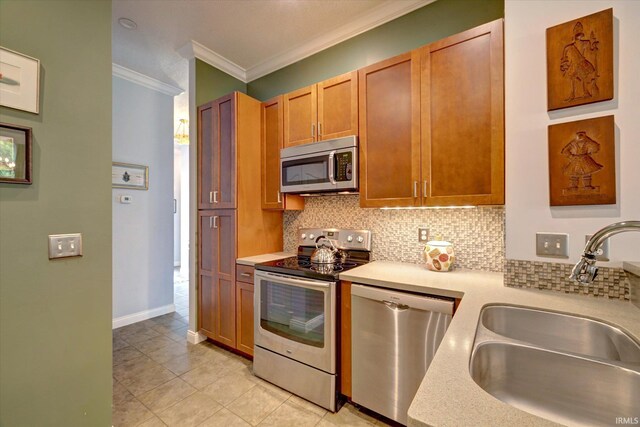 723 E Moss Creek Dr, Bloomington, IN 47401 - kitchen featuring appliances with stainless steel finishes, a sink, ornamental molding, decorative backsplash, and light countertops