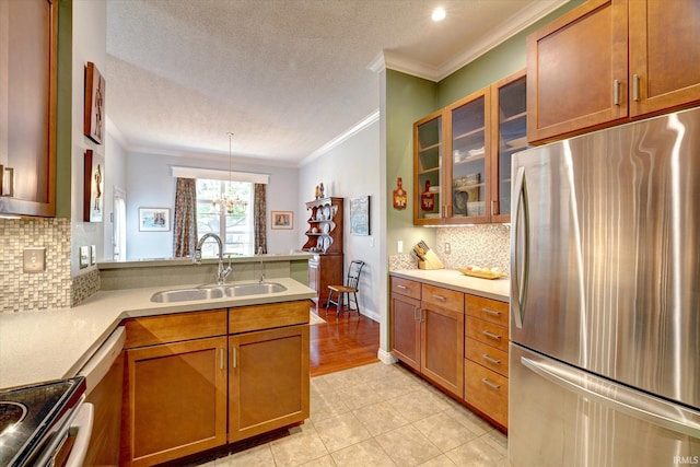 723 E Moss Creek Dr, Bloomington, IN 47401 - kitchen with stainless steel appliances, crown molding, a sink, a peninsula, and brown cabinets