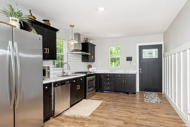 501 Spring Beach Rd, Rome City, IN 46784 - kitchen with appliances with stainless steel finishes, wall chimney range hood, a sink, and healthy amount of natural light