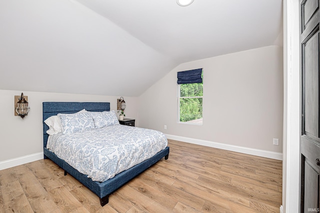 501 Spring Beach Rd, Rome City, IN 46784 - bedroom with lofted ceiling, light wood-style flooring, and baseboards