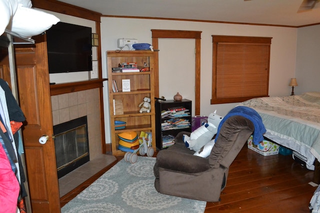 523 S Bluff St, Monticello, IN 47960 - bedroom with ornamental molding, a tile fireplace, and hardwood / wood-style flooring