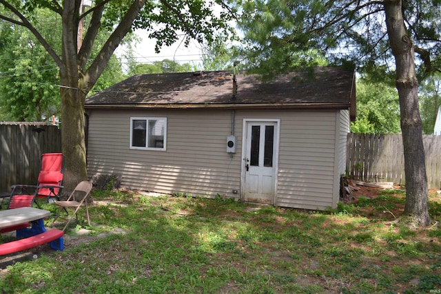 523 S Bluff St, Monticello, IN 47960 - back of property with a fenced backyard, an outdoor structure, and roof with shingles