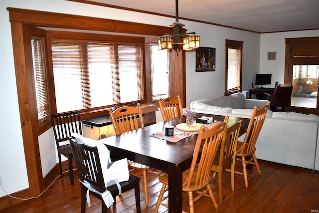 523 S Bluff St, Monticello, IN 47960 - dining space with dark wood-style floors, a chandelier, crown molding, and baseboards