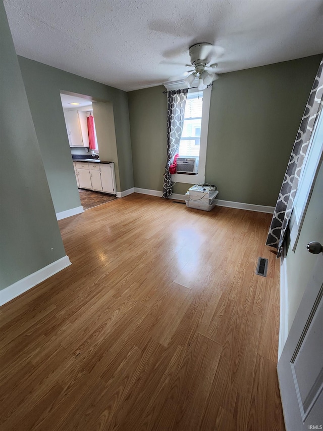 206 S Van Buren St, Monroe, IN 46772 - unfurnished room featuring wood finished floors, a ceiling fan, baseboards, and a textured ceiling